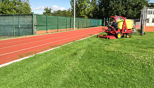 Mäharbeiten auf einem Sportplatz Mäharbeiten auf einem Sportplatz